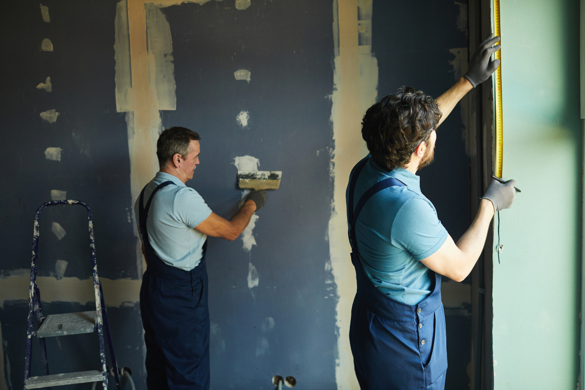 Two men painting a wall