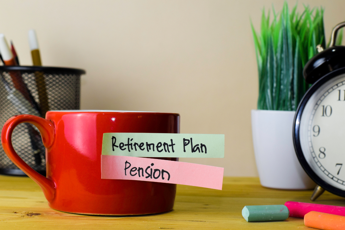 Retirement plan and pension written on sticky notes attached to a mug